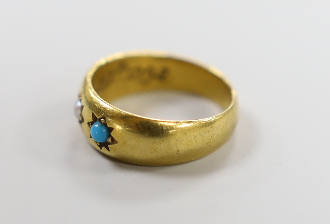 An early 20th century 18ct and gypsy set turquoise and seed pearl three stone child's ring, size A, gross weight 2.6 grams.